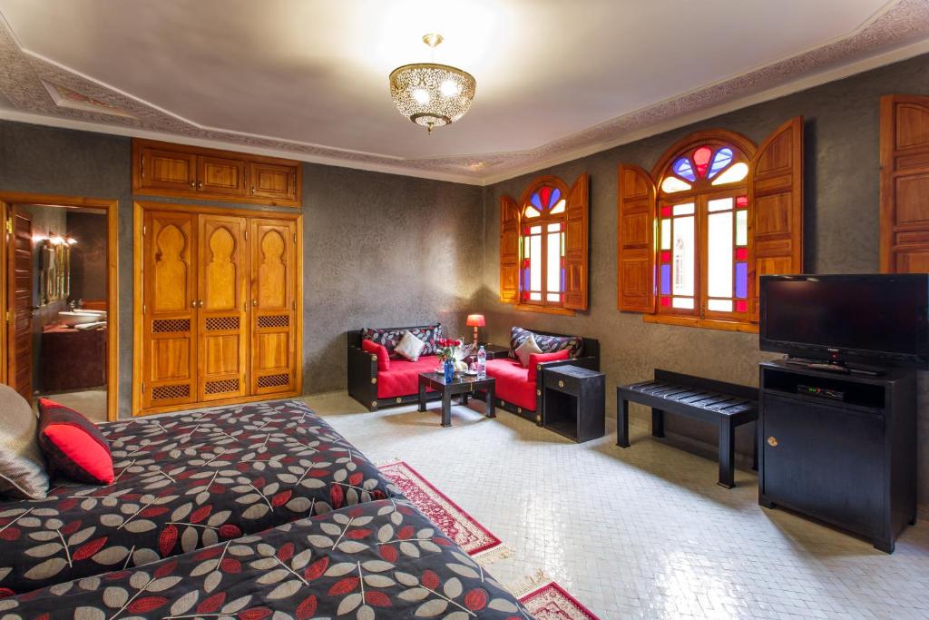 une chambre avec un lit et un salon dans l'établissement Riad Andalib, à Fès