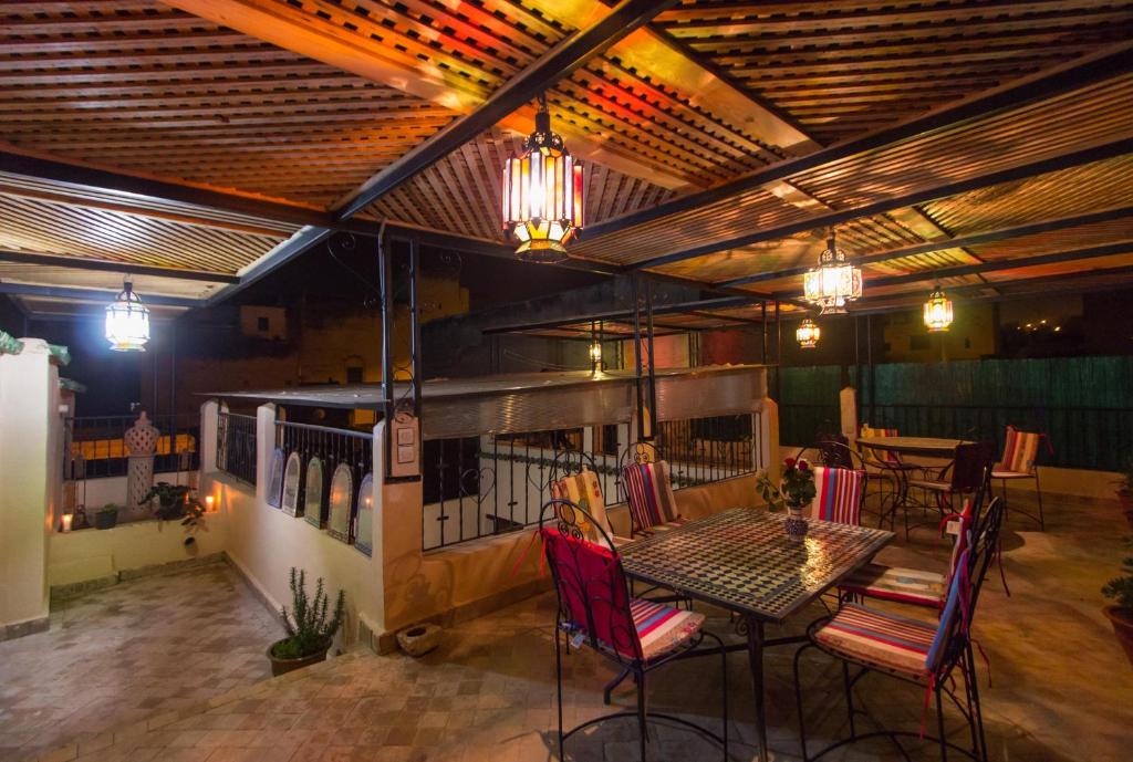 une salle à manger avec une table, des chaises et des lumières dans l'établissement Casa Aya Medina, à Fès