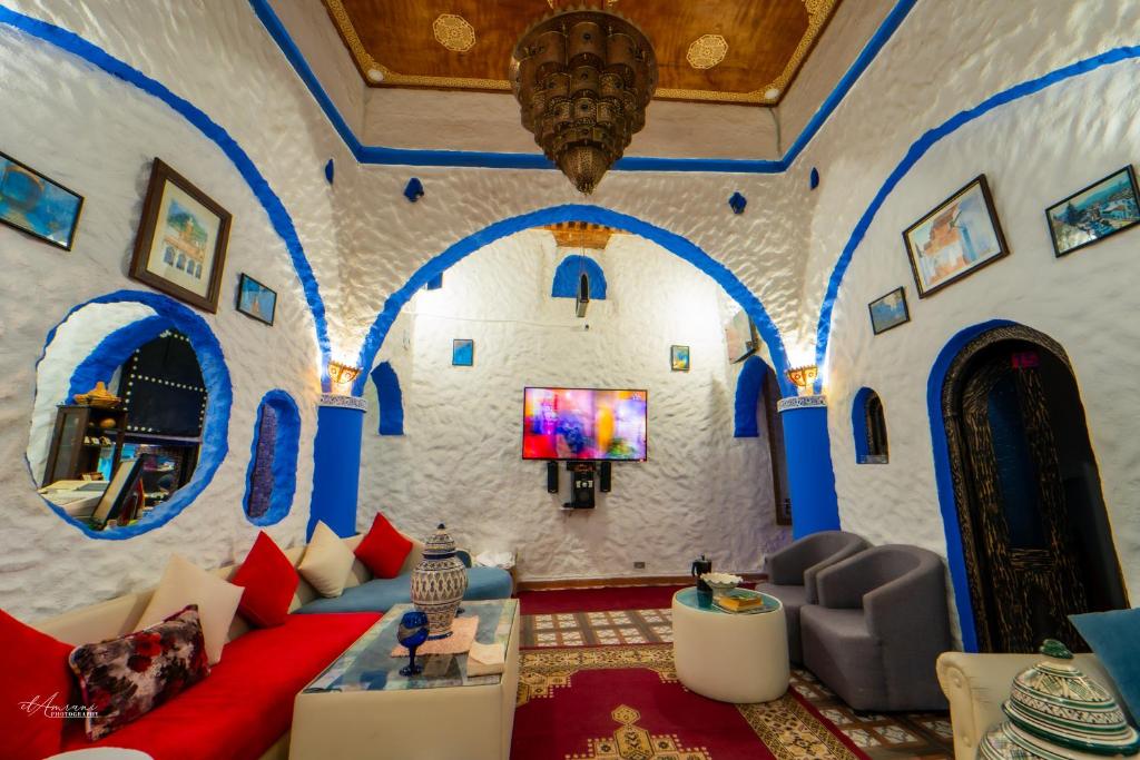 - un salon avec des murs bleus et blancs et un canapé dans l'établissement Riad Antek, à Chefchaouen