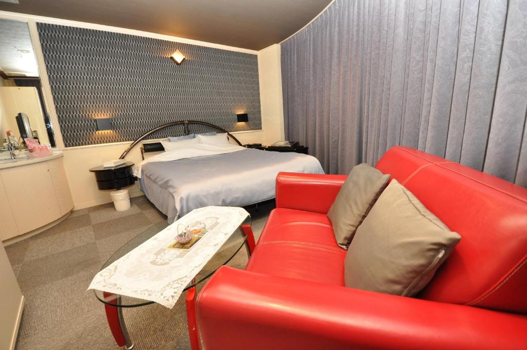 une chambre d'hôtel avec un lit et un canapé rouge dans l'établissement Hotel Boston Club (Adult Only), à Tokyo 21 autres photos
