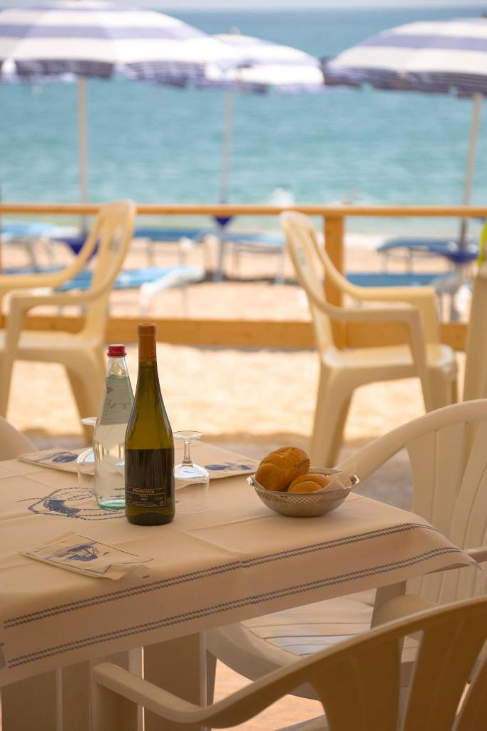 - une table avec une bouteille de vin et un bol de pain dans l'établissement Villaggio Riva Musone, à Porto Recanati