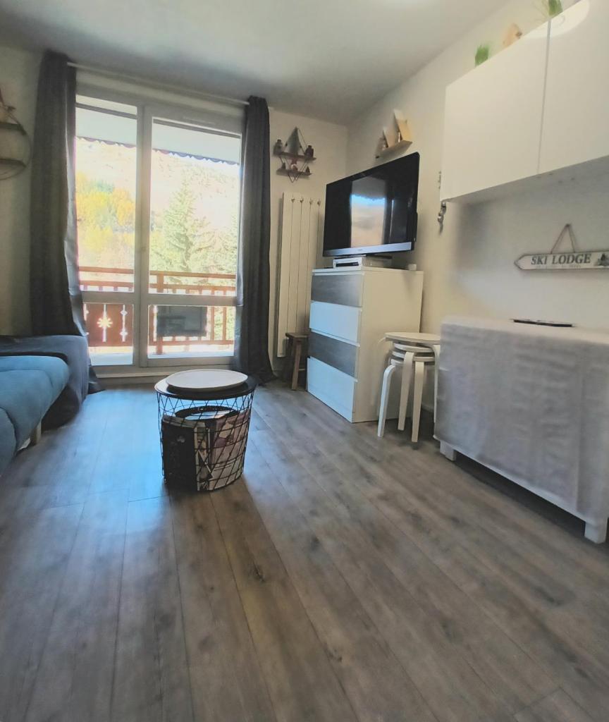 un salon avec une grande fenêtre et un canapé dans l'établissement Studio 2 alpes, proche lac buissonnière, ménage inclus, balcon, parking, à Les Deux Alpes
