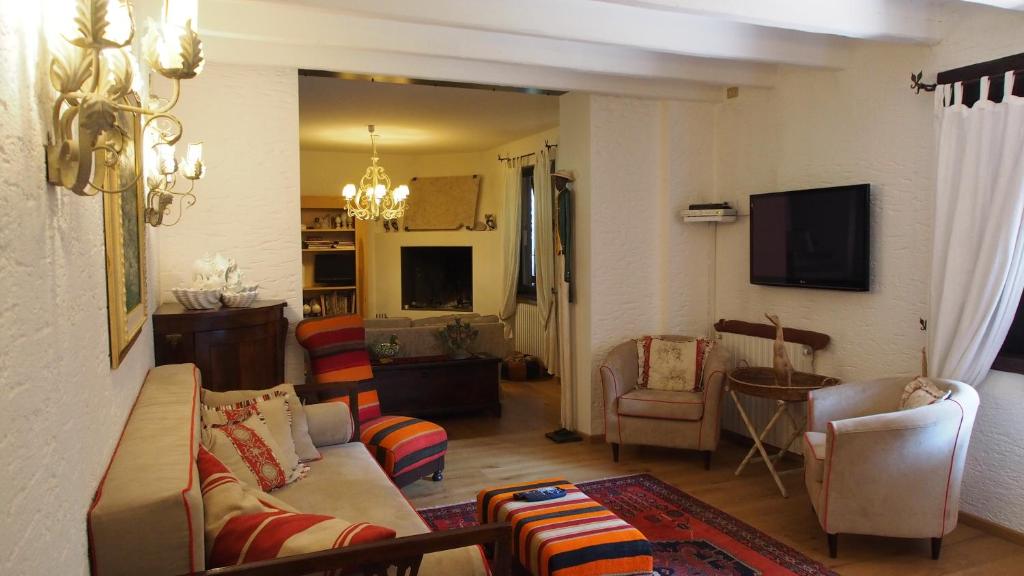 un salon avec un canapé, des chaises et une télévision dans l'établissement Villa Oliveto, à Padenghe sul Garda