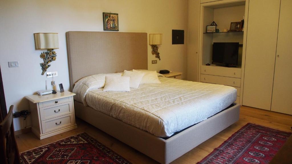 une chambre avec un grand lit et une télévision dans l'établissement Villa Oliveto, à Padenghe sul Garda 49 autres photos