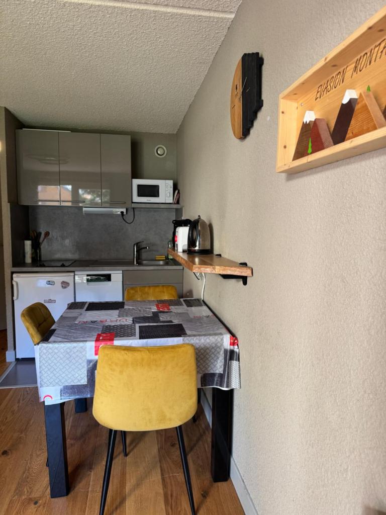 une petite cuisine avec une table et deux chaises dans l'établissement Superbe studio de montagne, au pied des pistes de ski, classé 3 étoiles, à La Morte