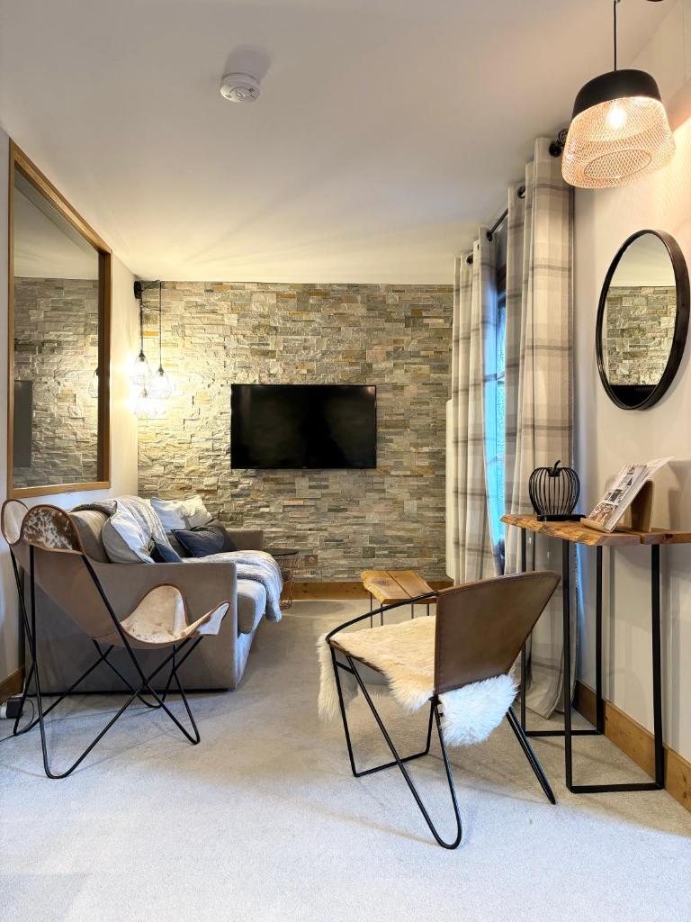 un salon avec un canapé et un mur de briques dans l'établissement Arc1950 Prince Des Cimes appt 4-5 pers ski in out piscine intérieure, à Arc 1950