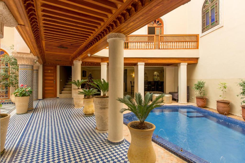 une maison dotée d'une piscine avec des plantes en pot dans l'établissement Riad Andalib, à Fès