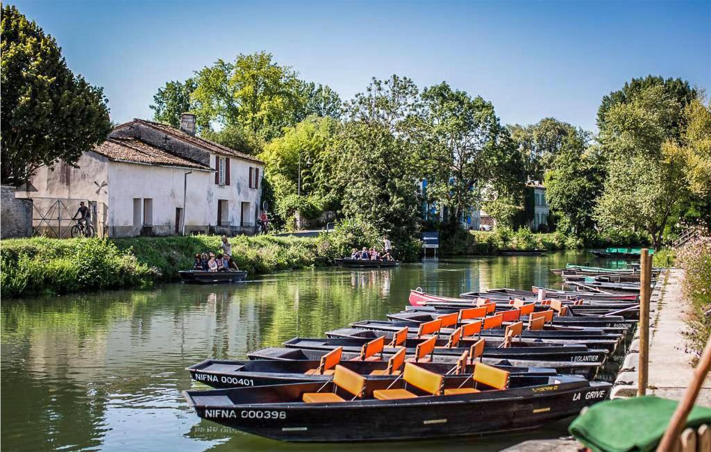 Une rangée de bateaux est alignée dans l'eau dans l'établissement Awesome StaCaravan In Chef-Boutonne, à Chef-Boutonne 20 autres photos