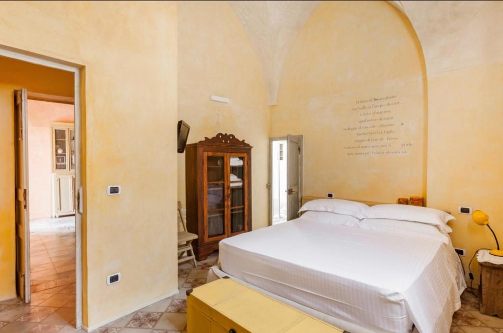 une chambre avec un grand lit blanc dans une pièce dans l'établissement Wp RELAIS LOCANDA FIORE DI ZAGARA, à Diso