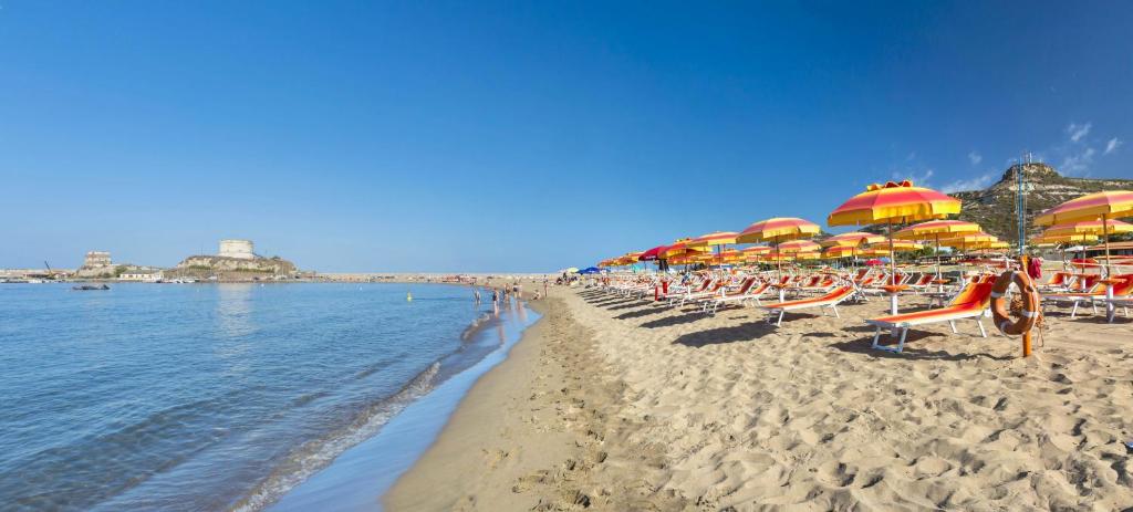 une plage de sable avec parasols et chaises et l'océan dans l'établissement ISA-Residence with private beach in Bosa Marina just 100 meters from the sea, à Bosa Marina