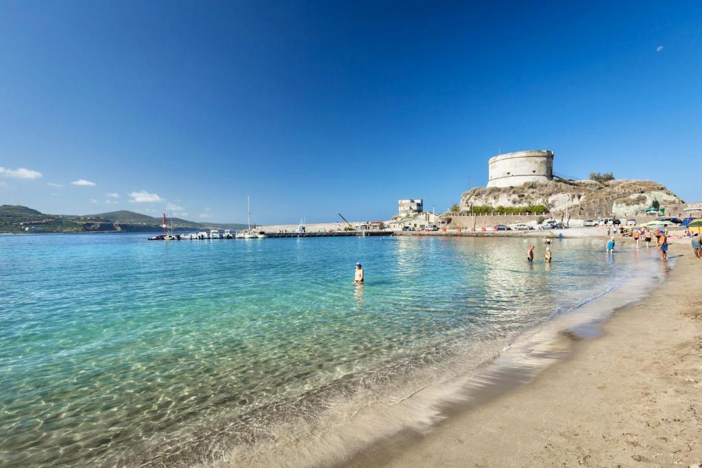un groupe de personnes dans l'eau sur une plage dans l'établissement ISA-Residence with private beach in Bosa Marina just 100 meters from the sea, à Bosa Marina