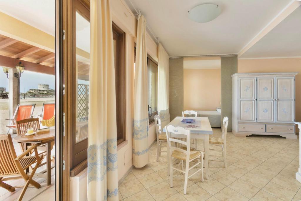 un salon avec une table et des chaises dans l'établissement ISA-Residence with private beach in Bosa Marina just 100 meters from the sea, à Bosa Marina