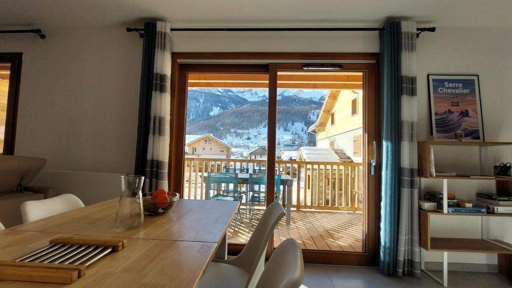 une salle à manger avec une table et une vue sur un balcon dans l'établissement Large new T2 with terrace le dahu perché, au Monêtier-les-Bains