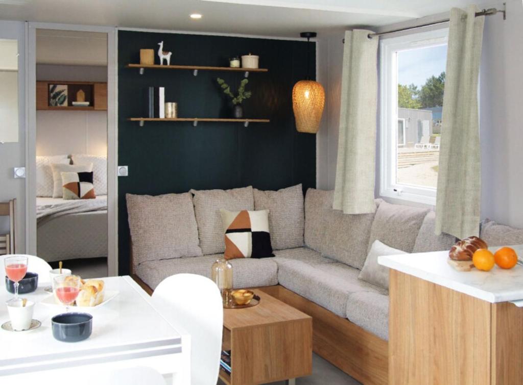 un salon avec un canapé et une table dans l'établissement MH 084 MAGNIFIQUE 2ch et 2sdb dont suite parentale au calme dans camping 4étoiles, à Saint-Julien-en-Born 15 autres photos