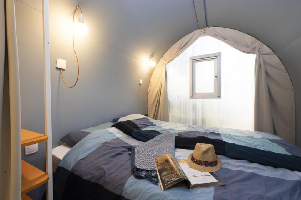 - une chambre avec une tente avec un chapeau sur un lit dans l'établissement Camping USHUAÏA Villages Au Bois Joli, à Andryes