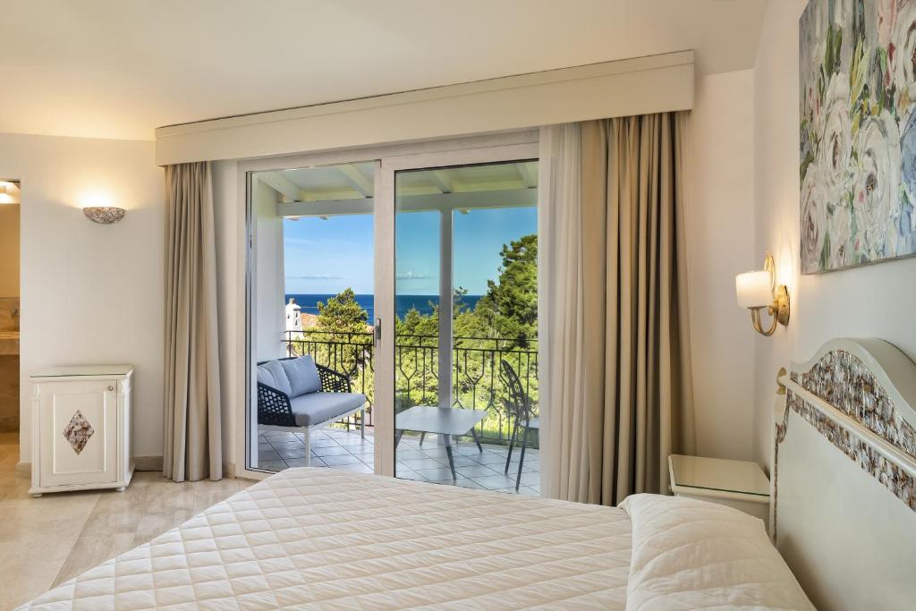 une chambre avec un lit et un balcon dans l'établissement Grand Hotel In Porto Cervo, à Porto Cervo