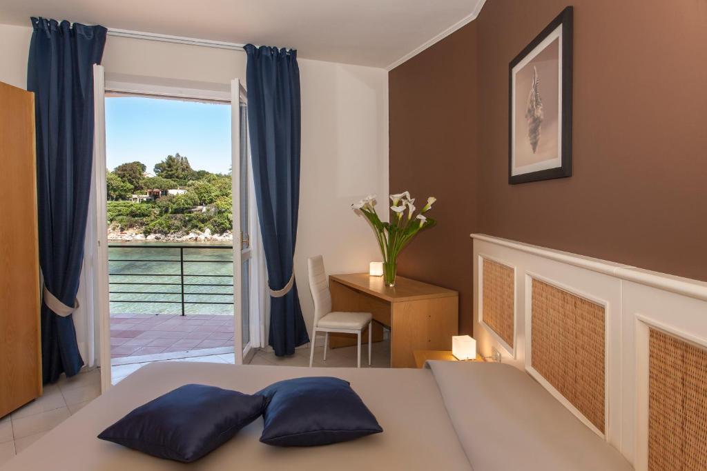 une chambre avec un lit et une fenêtre avec vue dans l'établissement Hotel Desiree, à Procchio