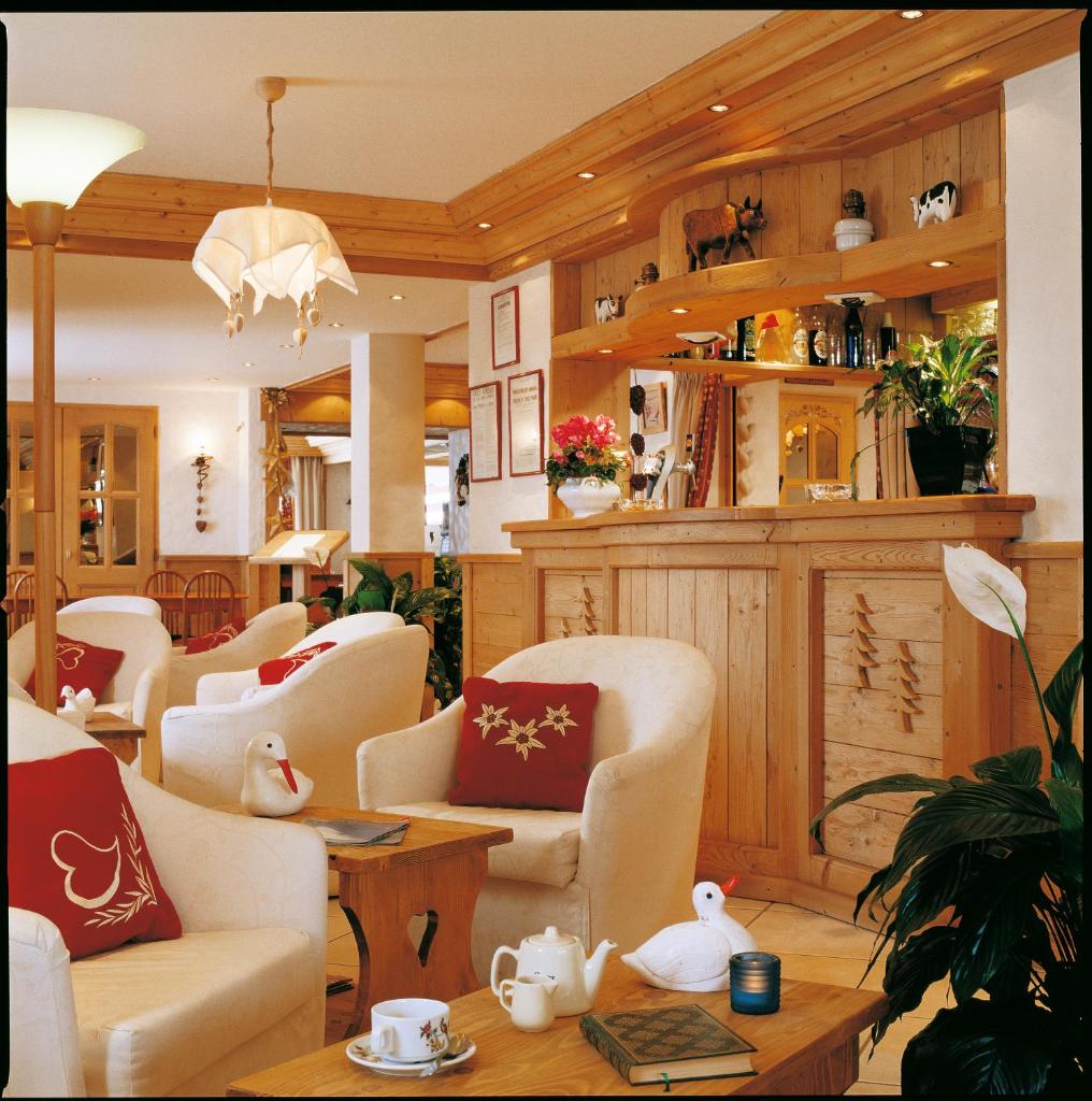 un salon avec des chaises blanches et une table dans l'établissement Hotel les Sapins, à La Clusaz