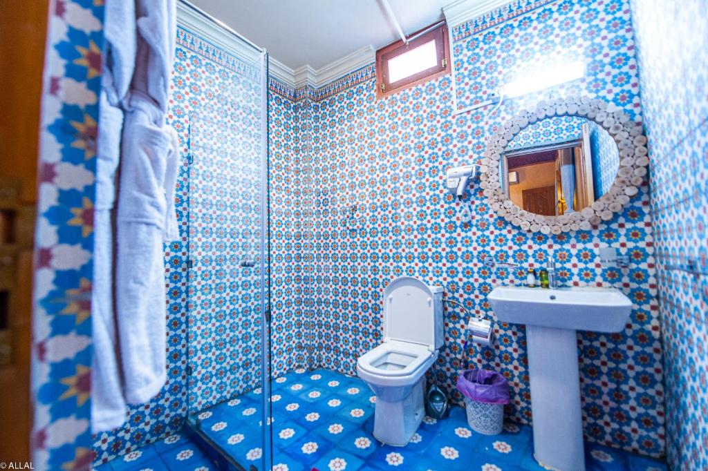 La salle de bains est pourvue de carrelage bleu, de toilettes et d'un lavabo. dans l'établissement Riad Almonds Marrakech, à Marrakech