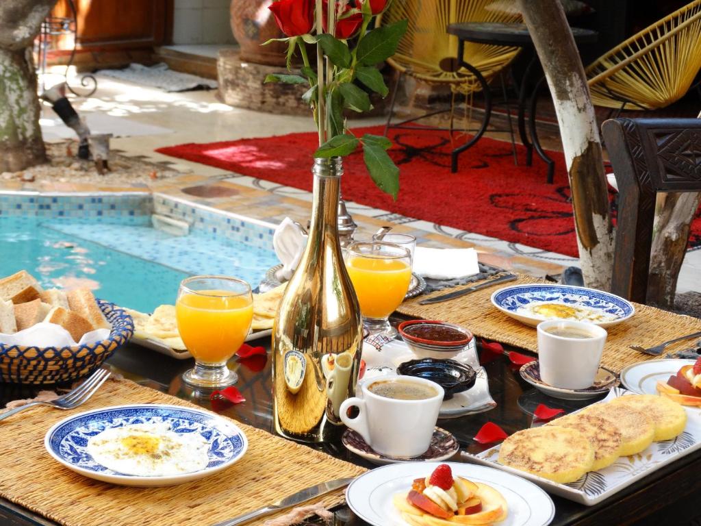 - une table avec des aliments pour le petit-déjeuner et un vase de fleurs dans l'établissement Riad Dar El Bacha, à Marrakech