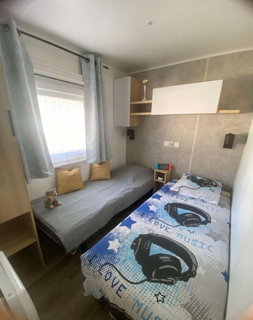 une petite chambre avec un lit et une fenêtre dans l'établissement Mobil home, à Parentis-en-Born