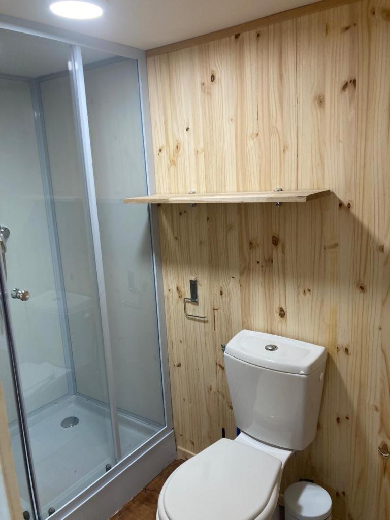 une salle de bain avec des toilettes blanches et une douche dans l'établissement Camping le Petit Liou Sites & Paysages, à Baratier
