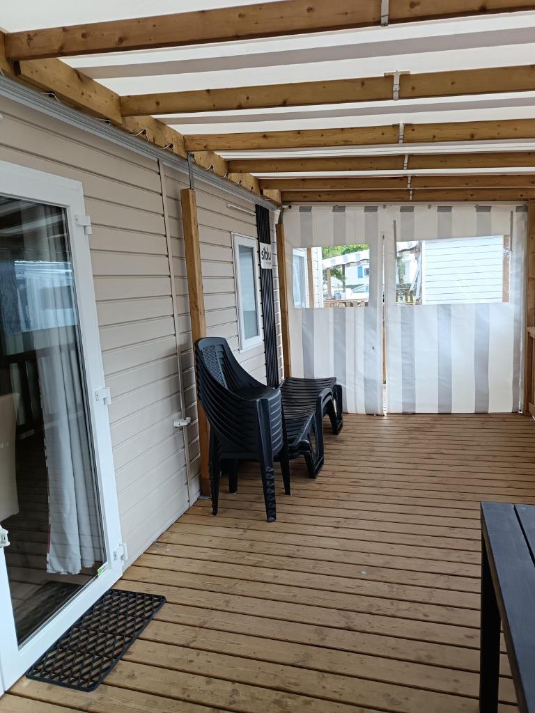 un porche couvert avec deux chaises sur une maison dans l'établissement MH F101 Camping Bois Masson, à Saint-Jean-de-Monts
