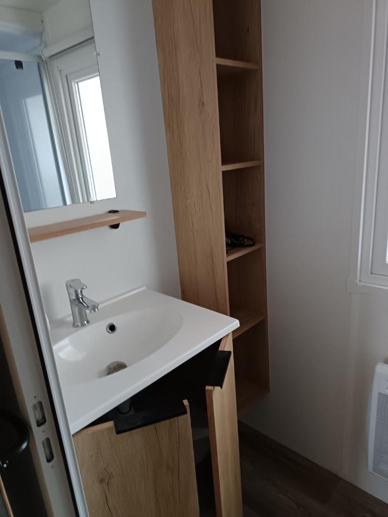 une salle de bain avec un lavabo et un miroir dans l'établissement MH F101 Camping Bois Masson, à Saint-Jean-de-Monts