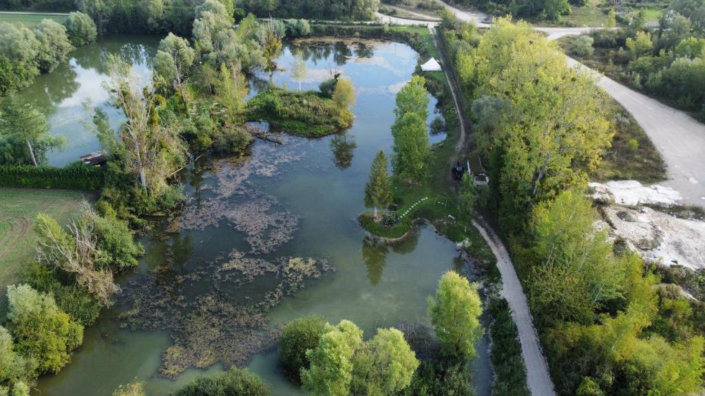 une vue aérienne sur une rivière arborée et une route dans l'établissement Yourte du pied de loup, à Saint-Thibault
