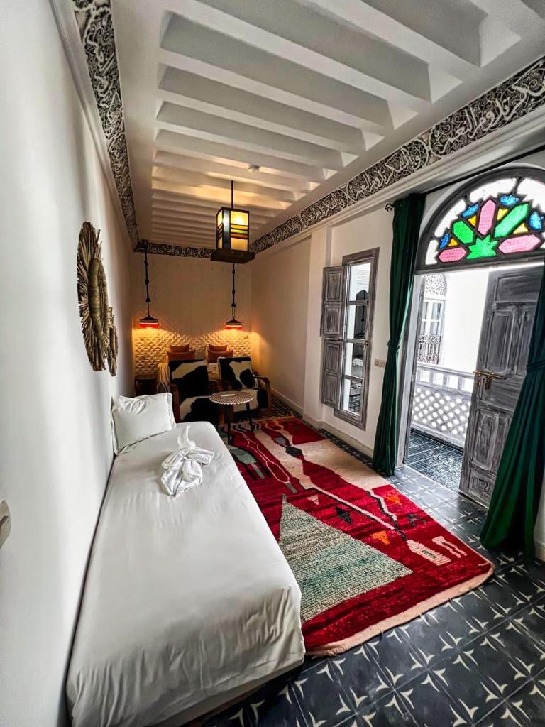 une chambre avec un lit et un salon dans l'établissement Riad dar darcom, à Marrakech