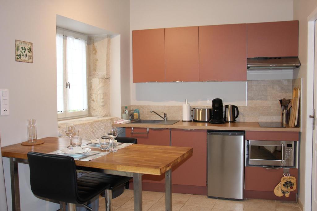une cuisine avec une table en bois avec des chaises et une tableasteryasteryasteryasteryasteryastery dans l'établissement Le Mazet, gîte des Lucioles en Provence, à Montségur-sur-Lauzon 25 autres photos