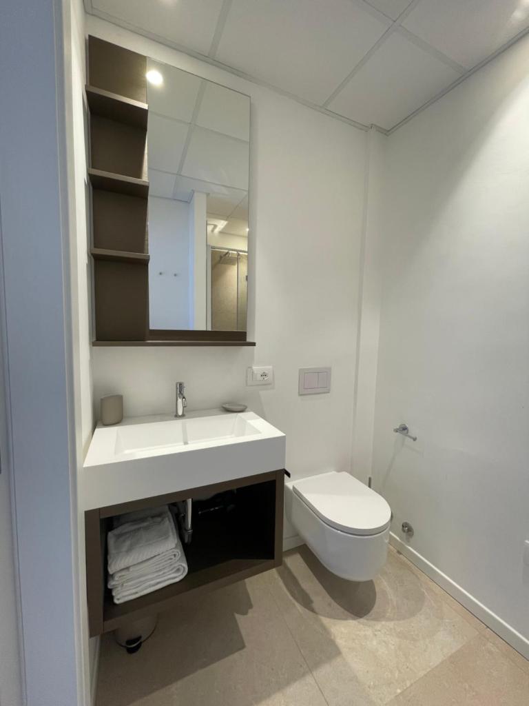 une salle de bain avec un lavabo, des toilettes et un miroir dans l'établissement Petit Hotel, à Caorle 29 autres photos