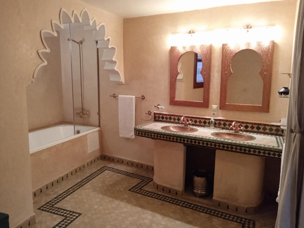une salle de bain avec deux lavabos et une baignoire dans l'établissement Riad Meyssane Fès, à Fès 37 autres photos