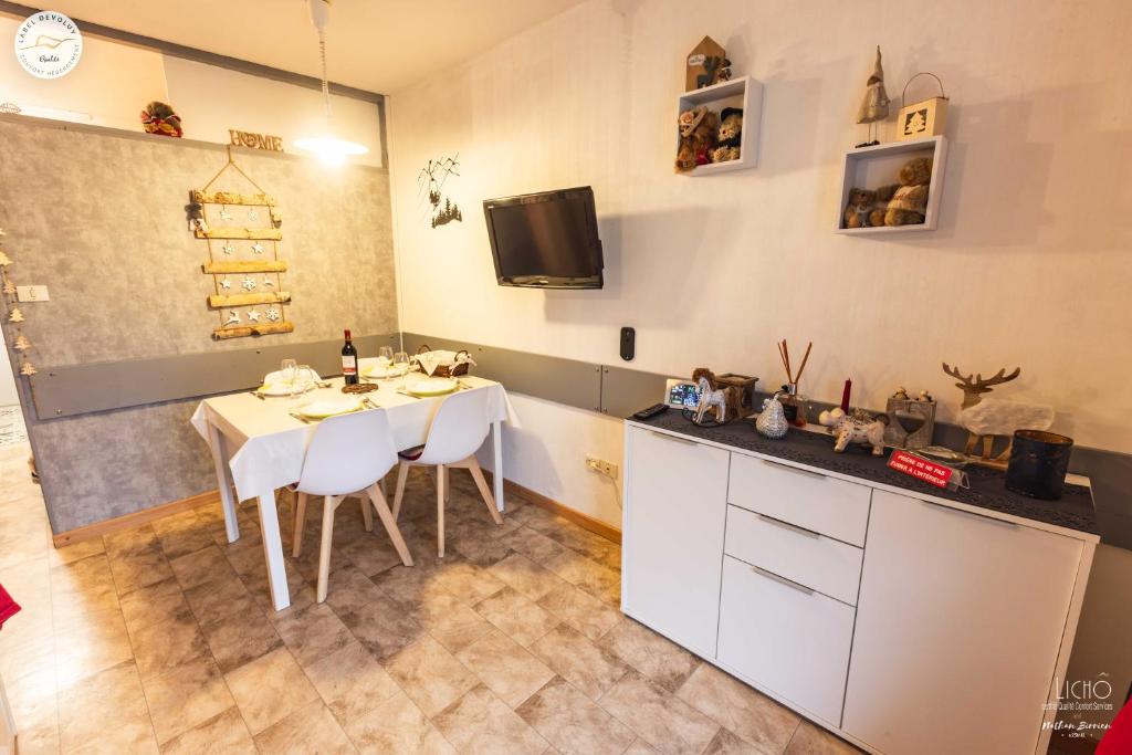 Il comprend une cuisine avec une table et des chaises ainsi qu'une télévision. dans l'établissement Superdevoluy Appart Rez de Neige, à Saint-Étienne-en-Dévoluy