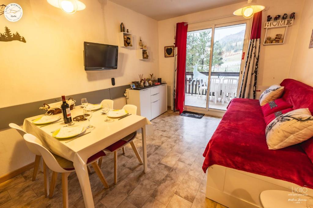 - un salon avec une table à manger et un lit dans l'établissement Superdevoluy Appart Rez de Neige, à Saint-Étienne-en-Dévoluy