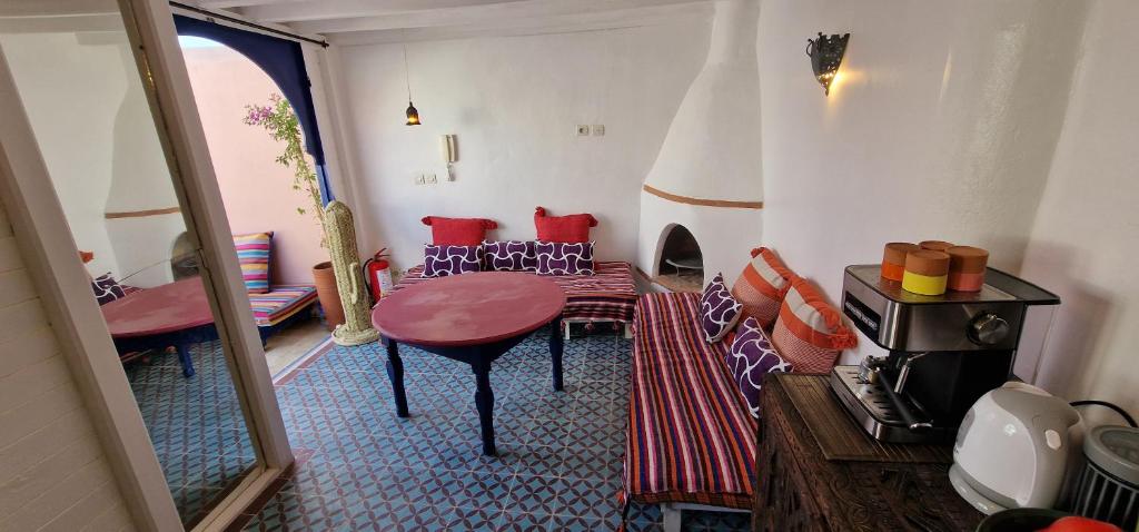une pièce avec une table et des chaises dans une pièce dans l'établissement DAR DAREK FAMILY, à Essaouira