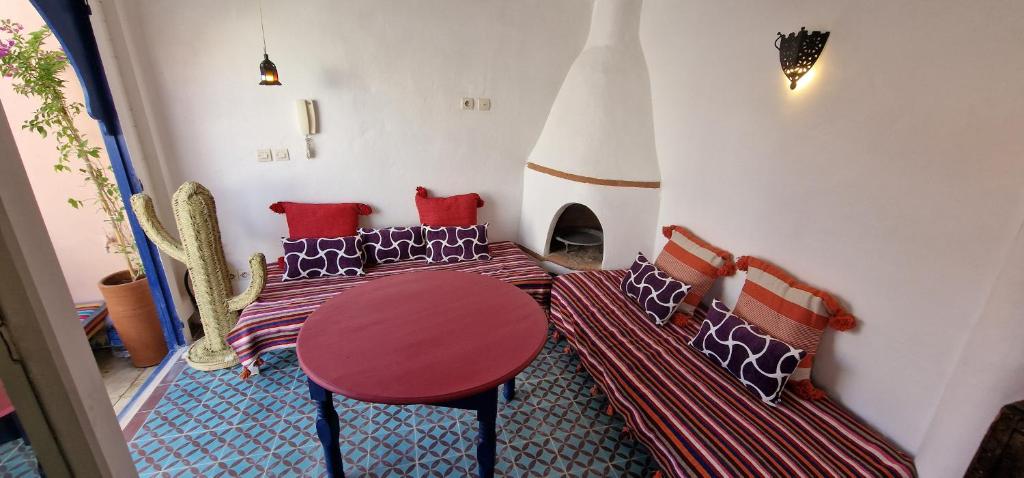 une chambre avec deux lits, une table et des chaises dans l'établissement DAR DAREK FAMILY, à Essaouira