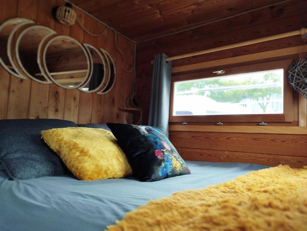 - un lit avec deux oreillers dans une chambre dotée d'une fenêtre dans l'établissement La Toue Charme, à Angers 6 autres photos