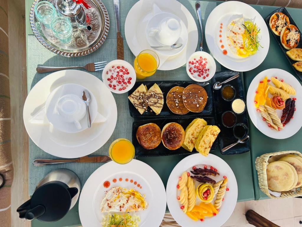 une table remplie d'assiettes de nourriture et de boissons dans l'établissement Yacouta Riad and Spa, à Marrakech 18 autres photos