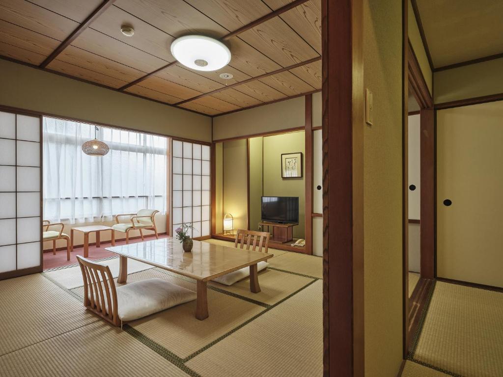 une chambre avec une table et un salon dans l'établissement Manseiro, à Nachikatsuura