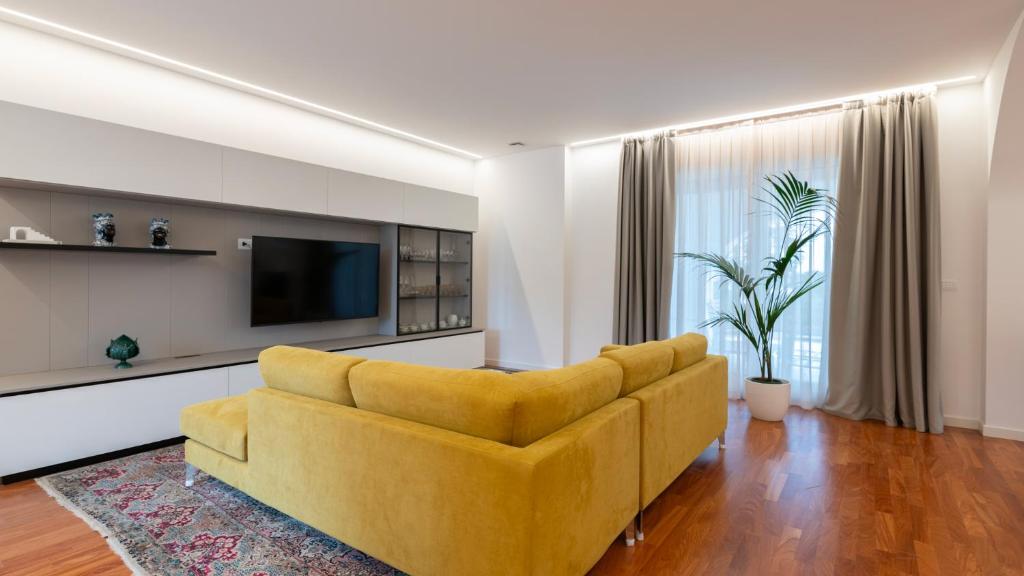 - un salon avec un canapé jaune et une télévision dans l'établissement VILLA BELLINA 6, Emma Villas, à Ostuni