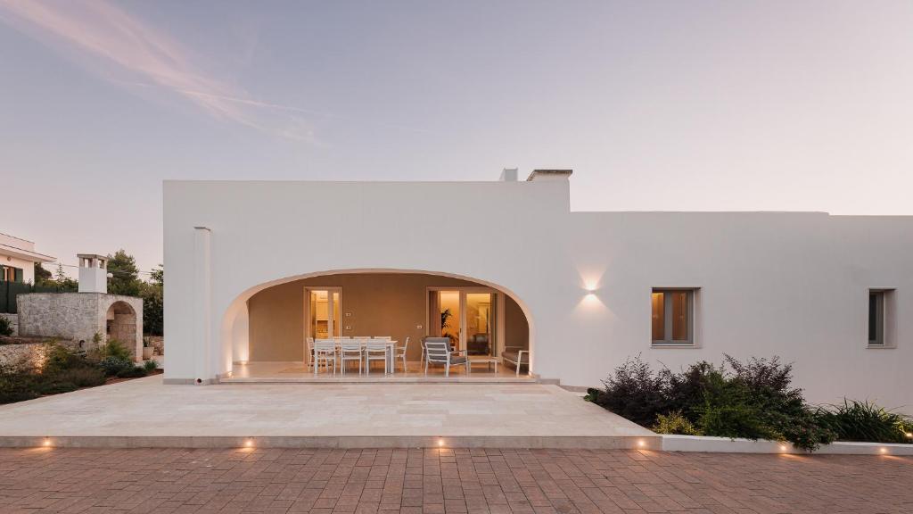 Cette maison blanche dispose d'une terrasse et d'une arche. dans l'établissement VILLA BELLINA 6, Emma Villas, à Ostuni