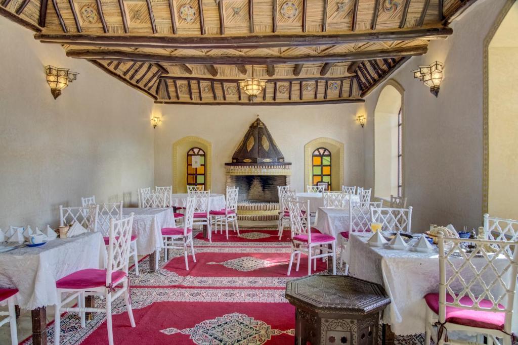 Cette chambre dispose de tables et de chaises blanches ainsi que d'une cheminée. dans l'établissement Riad Jnane Ines, à Taroudant 37 autres photos