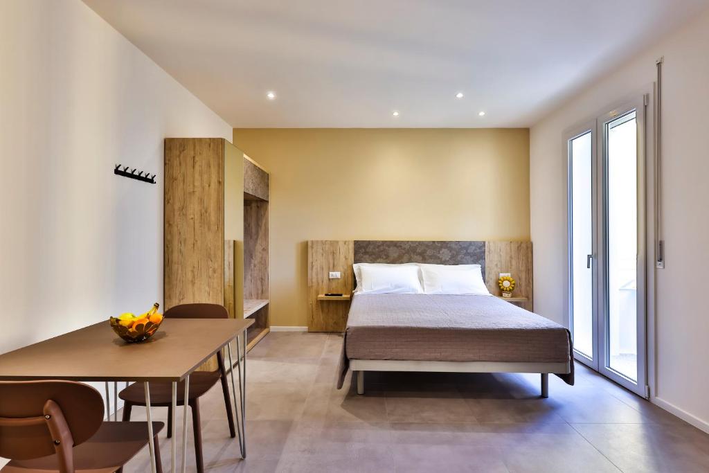 une chambre avec un lit, une table et des chaises dans l'établissement Apho Apartment Hotel, à Rimini