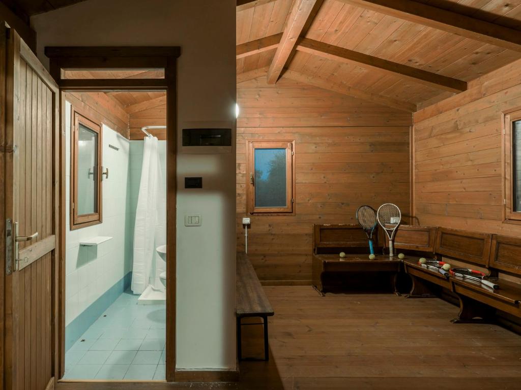 La salle de bains est pourvue de murs en bois, de toilettes et d'un lavabo. dans l'établissement TENUTA NAVELLI 12&2, Emma Villas, à Salò