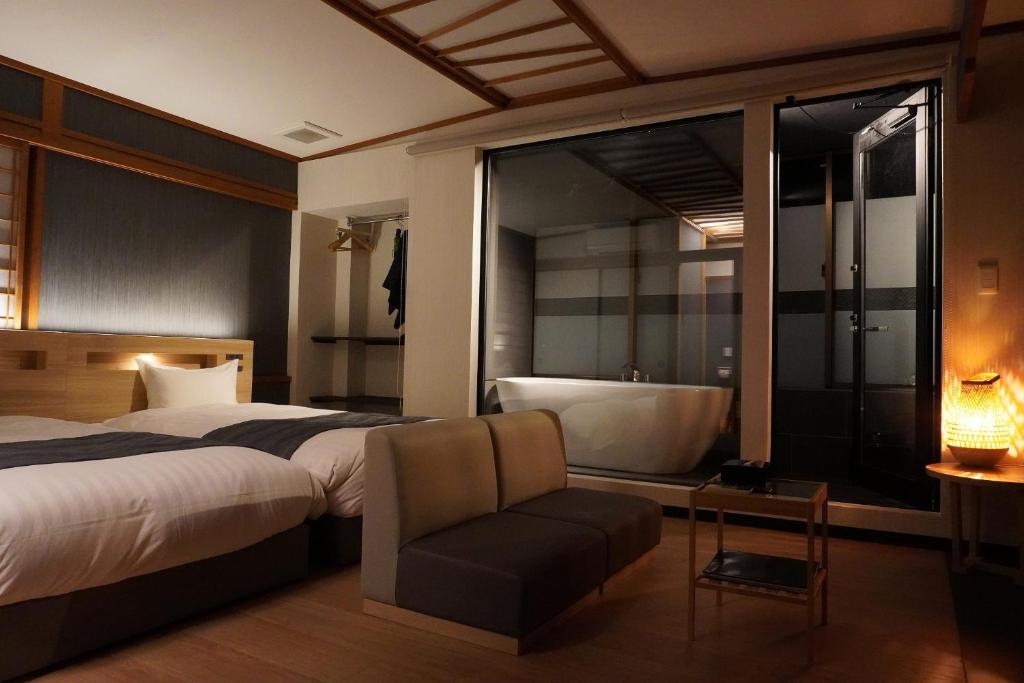 une chambre avec un grand lit et une baignoire dans l'établissement AWA Nishi-Izu, à Numazu