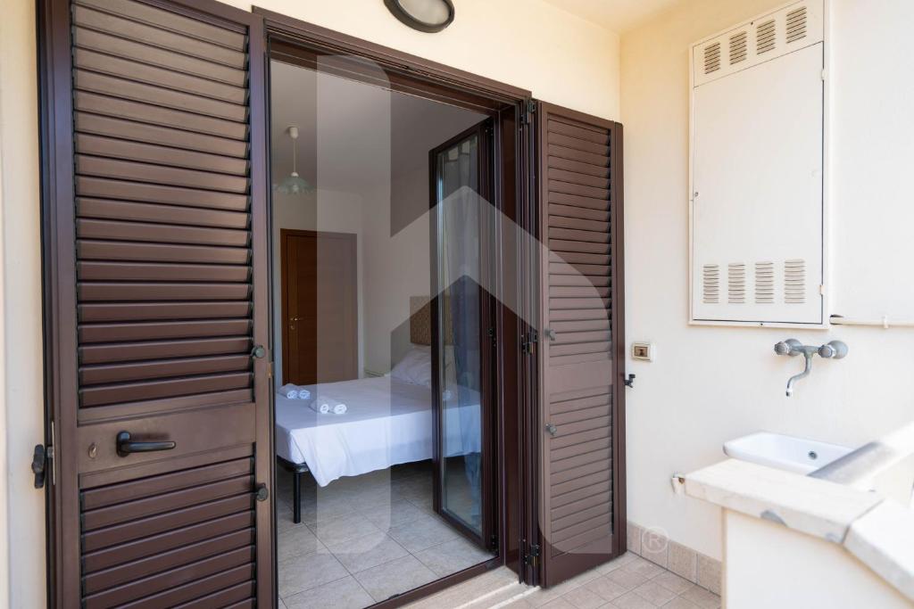 une salle de bain avec une porte vitrée avec un lavabo dans l'établissement Homiday - Residence Micaene, à Pineto