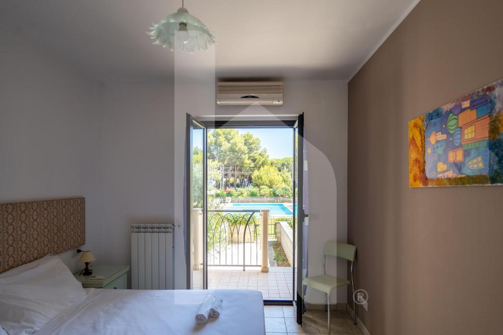 une chambre avec un lit et une vue sur une piscine dans l'établissement Homiday - Residence Micaene, à Pineto