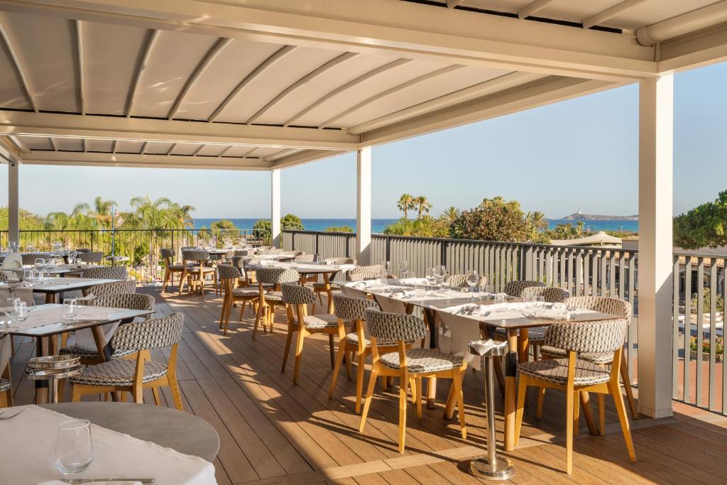 un restaurant avec des tables et des chaises sur une terrasse dans l'établissement VOI Tanka Selected, à Villasimius