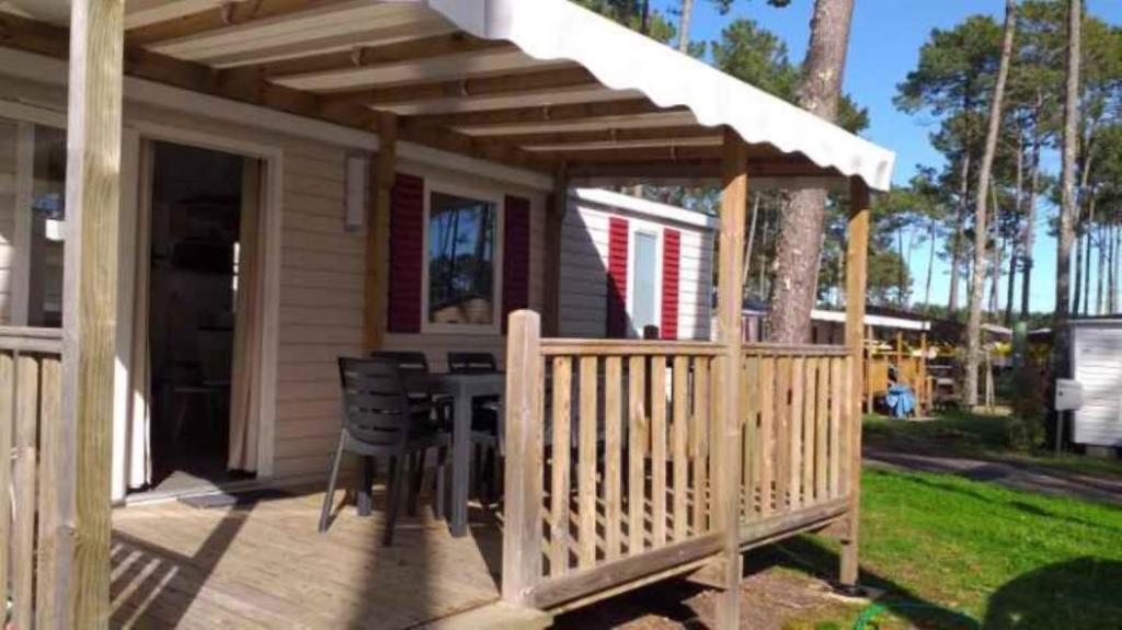 une terrasse en bois avec pergola sur une maison dans l'établissement MH 538 TOUT EQUIPE et TOUT CONFORT 2ch 1sdb dans camping 4 étoiles, à Saint-Julien-en-Born